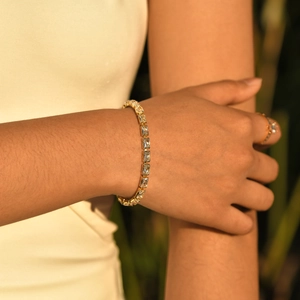Elegantes goldenes Tennisarmband mit rechteckigen Zirkoniasteinen am Handgelenk