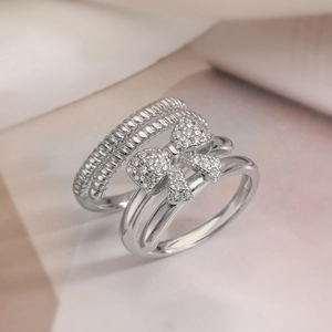 Macro shot of silver-tone double-layered bow ring with sparkling zircon stones