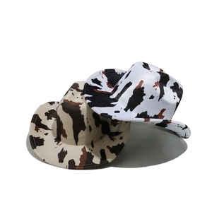 Fashionable cow print felt cowboy hats in black and brown patterns on white background