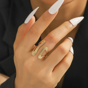 Detailansicht eines Goldrings mit gerillter Textur und gewelltem Design an der Hand
