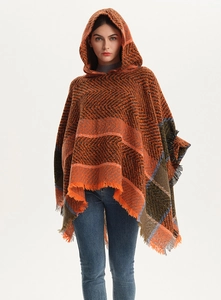 Detail of herringbone pattern knit poncho with vibrant orange fringed edges and hood