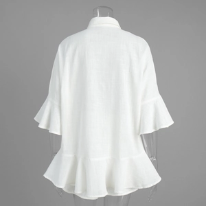 Détail de la chemise blanche en lin avec manches à volants et ourlet vue de l'arrière