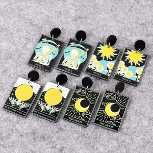Macro view of printed acrylic tarot card earrings featuring skull and moon designs