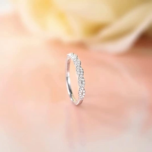 Macro shot of silver wedding band with wave design and sparkling pave diamonds