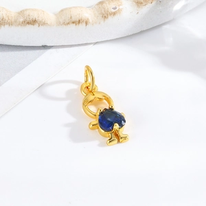 Macro detail of a golden girl-shaped pendant featuring a blue heart gemstone