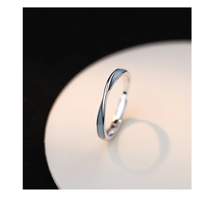 Macro shot of silver luminous butterfly ring featuring a blue enamel mobius design band