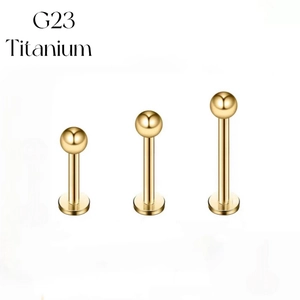 Three gold G23 Titanium labret studs for lip and ear cartilage piercings on white background
