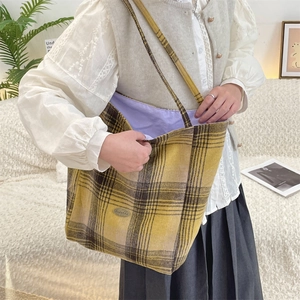 Detail of wool tote bag featuring ginger plaid pattern and soft purple cotton lining