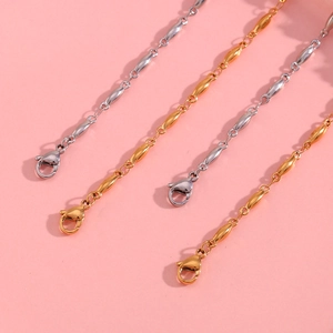 Detail of 18K gold and silver beaded chains with lobster clasps on pink background