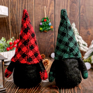 Set di gnomi di Natale con cappelli in maglia scozzese rossi e verdi su fondo legno