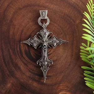 Vintage Gothic cross pendant necklace with skull motif on dark wood background