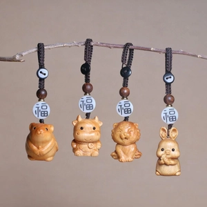 Close-up of hand-carved cedar wood Chinese zodiac charms with lucky beads and woven cord