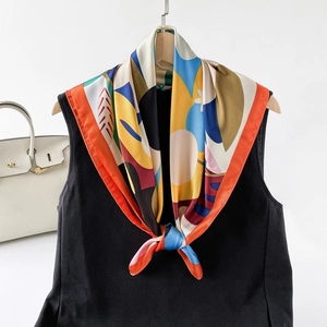 Detail of silk square scarf with abstract artistic print and orange rolled edges