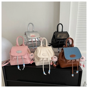 Dettaglio di cinque mini zaini in pelle PU colorata con ciondoli a forma di mostro