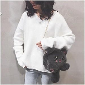 Détail du sac chat en peluche gris foncé avec chaîne dorée porté par un modèle