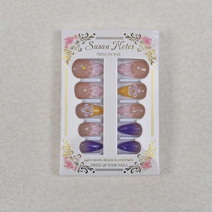 Detail of almond press-on nails featuring 3D floral patterns and shell pearl textures