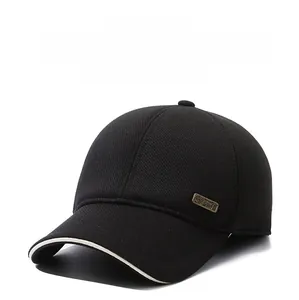 Detail of black winter baseball cap showing corduroy texture and metal logo plaque