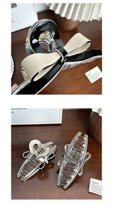 Detailed view of elegant black and white bow hair clips with acetate finish for women