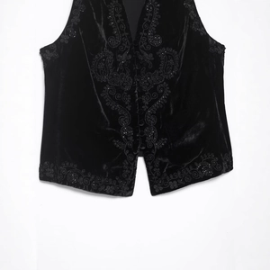Fashionable black velvet vest with intricate bead and sequin embroidery on white background