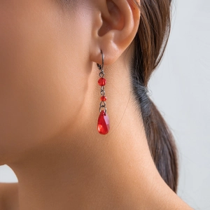 Close-up of gothic blood red water drop earrings with vintage dark metal hooks