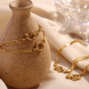 Detail of 18K gold-plated chunky link and snake chain jewelry with round spring clasp