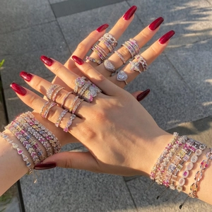 Macro shot of silver tennis bracelets and multi-color zircon rings on a woman's hand