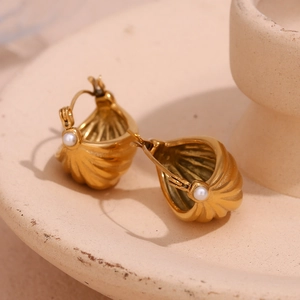Macro shot of 18K gold plated basket earrings with pearl accents and ribbed shell texture