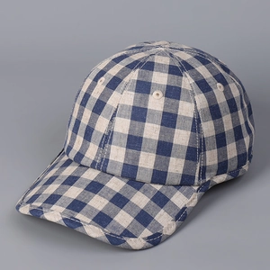 Detailed close-up of blue and beige checkered linen baseball cap texture and stitching