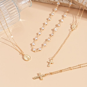 Gold layering necklace set with faux pearls, cross charms, and virgin mary medallion