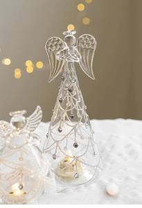 Close-up of glass angel with LED light and silver glitter mesh patterns on the dress