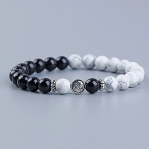 Detailed close-up of Tai Chi Yin Yang charm and marbled white turquoise beads on elastic bracelet