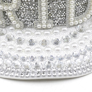 Détail du chapeau de fête blanc avec strass argentés et lettrage BRIDE en perles fines