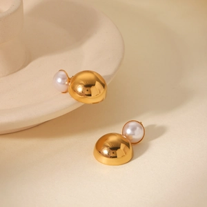 Detail of 18k gold plated half-round earrings with white pearls on a minimalist backdrop