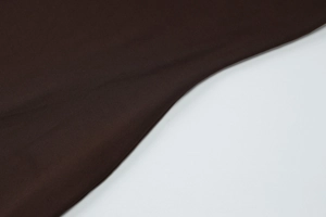 Detailed macro view of deep brown fabric texture and elegant drape on dress