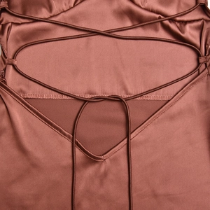 Détails du dos nu de la robe en satin avec bretelles croisées et coutures de précision