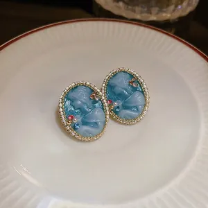 Vintage relief earrings with blue goddess cameo and pearls on ceramic plate