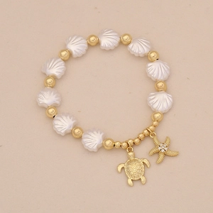 Detailed macro view of beaded bracelet with 18K gold starfish and turtle charms