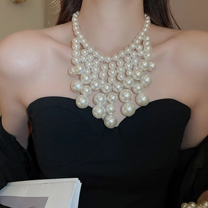 Detail of elegant multi-layered white faux pearl collar necklace with cascading beads