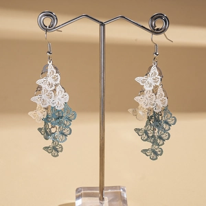 Detail of hollow butterfly drop earrings with blue-white gradient and tiered tassels