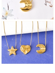 Detailed view of three gold titanium steel necklaces with star, heart, and moon pendants