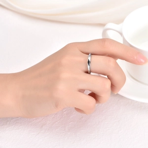 Close-up of a silver geometric diamond-cut rotating ring worn on the index finger