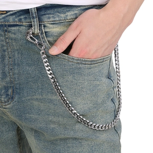 Detail of silver skull head biker wallet chain hanging on blue denim jeans pocket