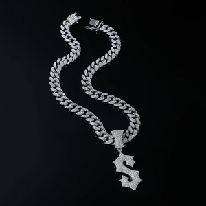 Detailed view of silver iced-out Cuban chain with dollar sign pendant on dark background