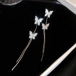 Detail of gold-plated butterfly earrings with cascading tassels and sparkling rhinestones