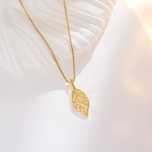 Elegant gold leaf pendant necklace with zircon crystals on a delicate box chain