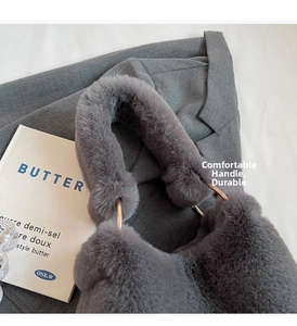 Detail of grey faux fur tote bag with plush handles and decorative golden metal ring