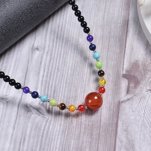 Detailed view of solar system theme necklace with 6mm natural stone beads on wood