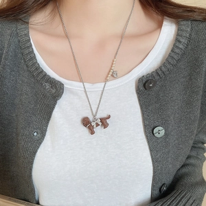 Detail of silver necklace with brown puppy pendant and rhinestones on a female model