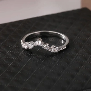 Macro shot of silver V-shape crown ring with sparkling round stones on black quilted box