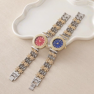Détail de montres de luxe avec strass, cadrans rouge et bleu et bracelets bicolores